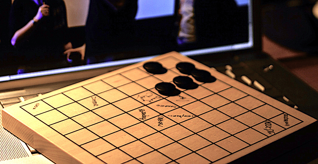 Fotografia planszy do gry w Go na klawiaturze laptopa